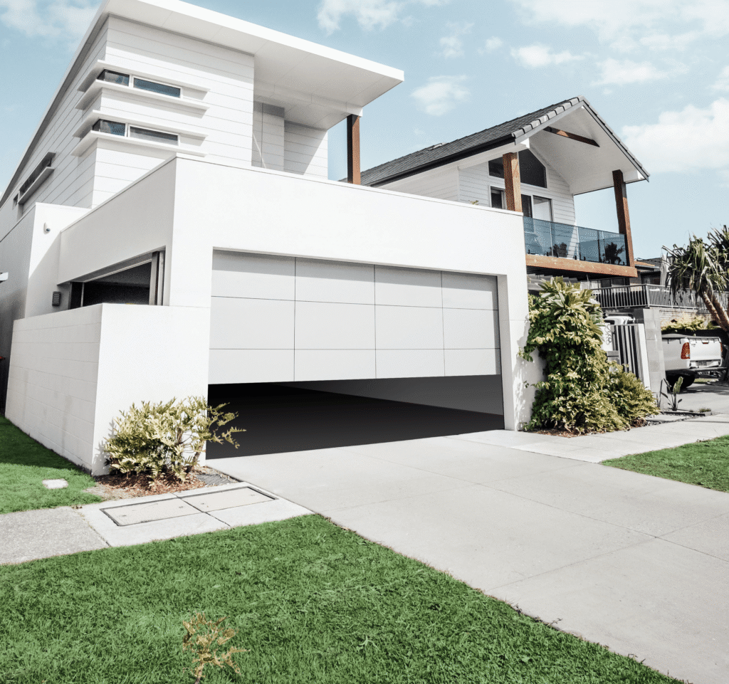 White house with automatic garage door lifting on suburban street