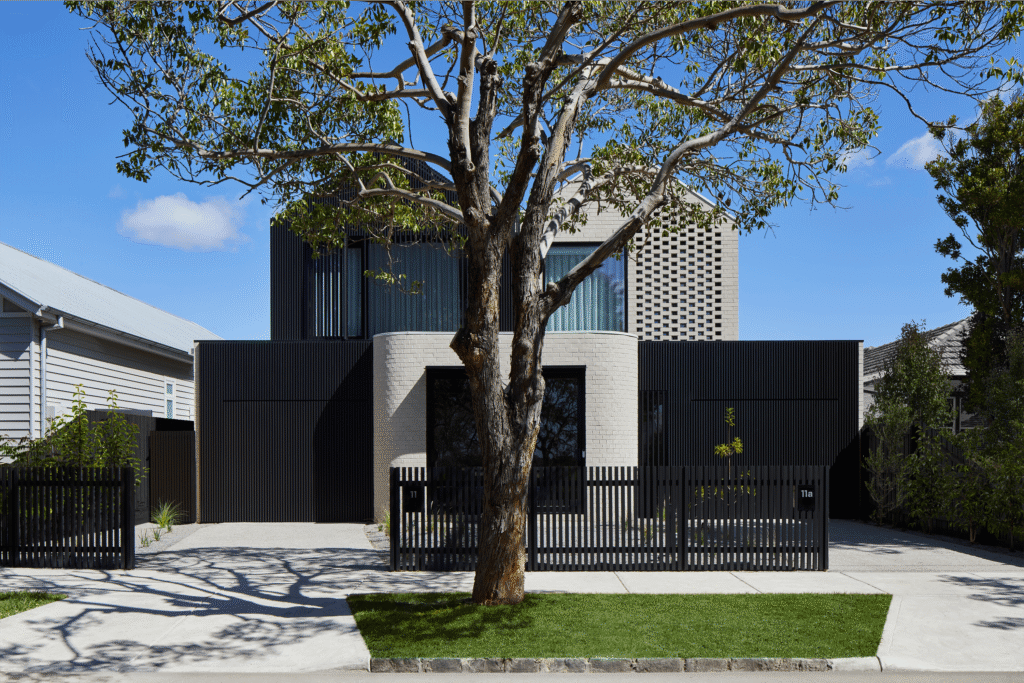dual suburban townhouse with black fence and automatic garage doors