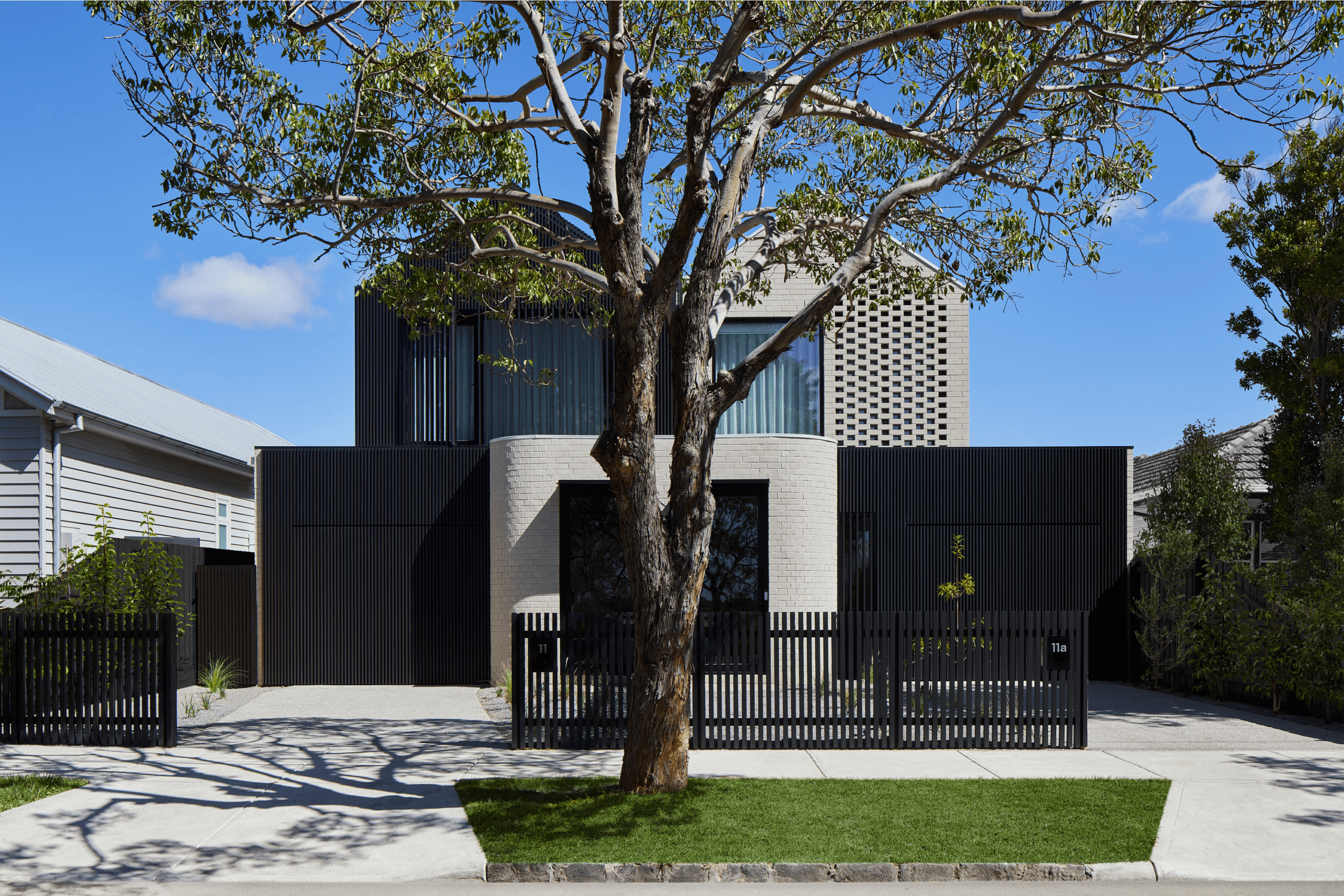 dual suburban townhouse with black fence and automatic garage doors