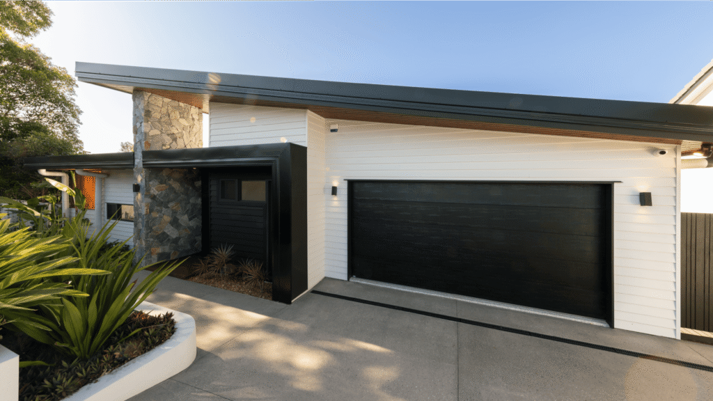black sloped roof suburban house with double door black automatic door garage